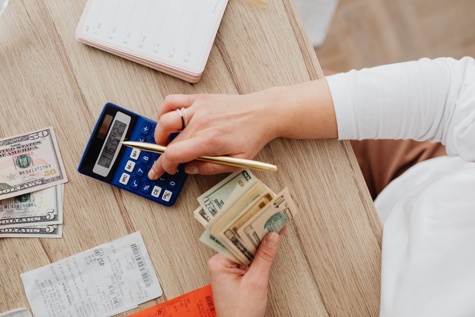 Hands-on financial planning — calculating a household budget with cash, receipts, and a calculator